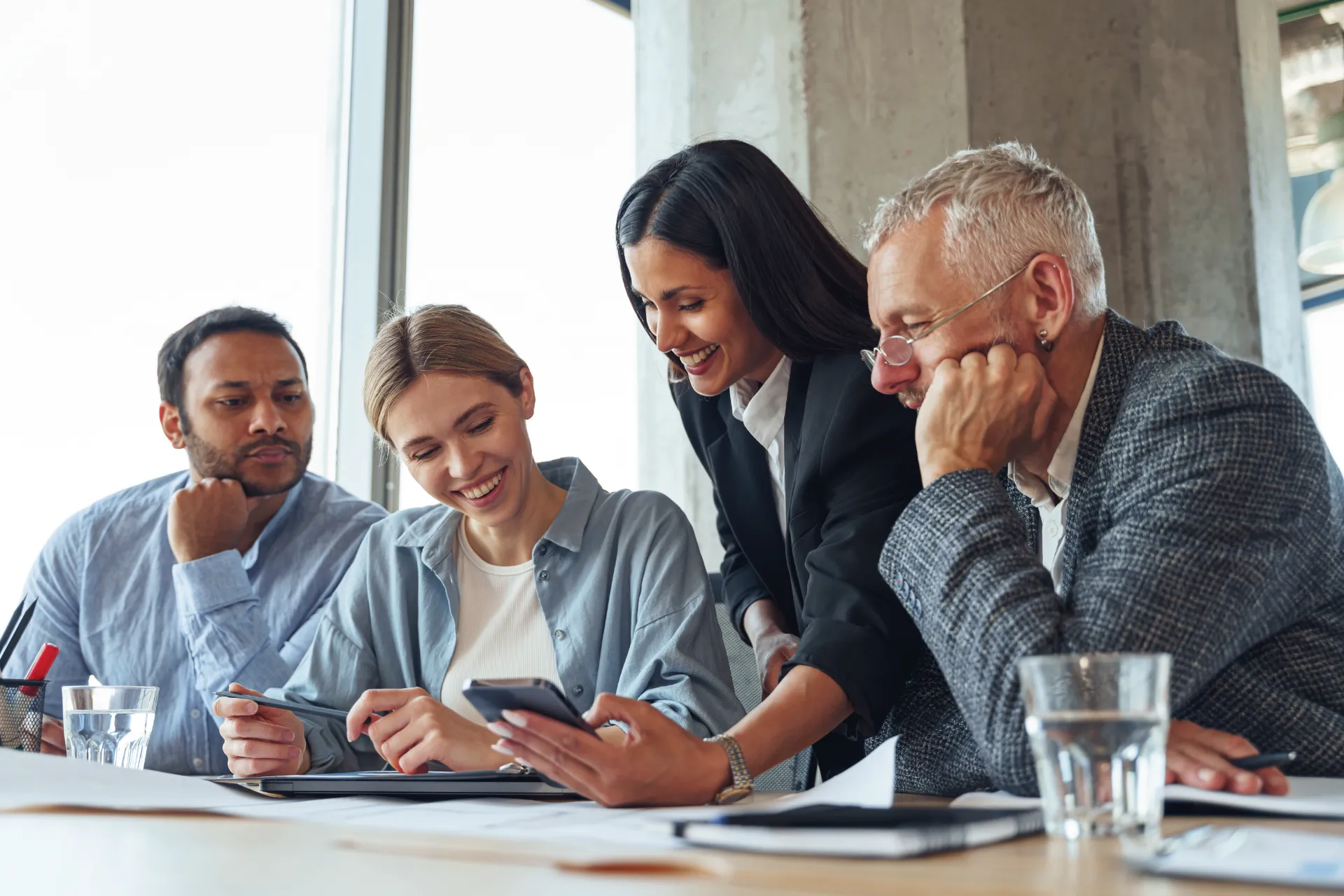 Woman manager showing her colleagues idea project smartphone meeting room
